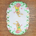 Wielkanocna serwetka 30x45 w kolorze białym z zajączkami i pisankami, błyszcząca nitka